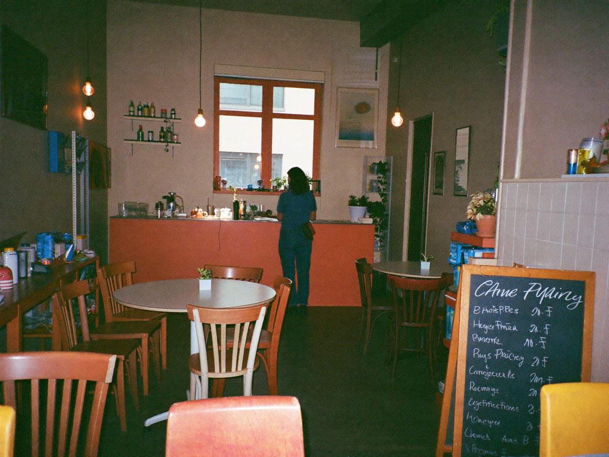 A quiet independent café interior on a slow weekday, owner behind the counter